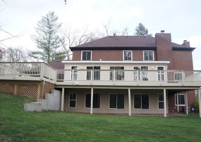 rear view of house featuring a wooden deck and a yard