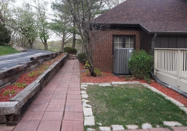 view of property exterior with central AC unit and a lawn