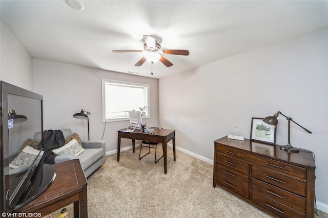 home office featuring a textured ceiling, light colored carpet, and ceiling fan