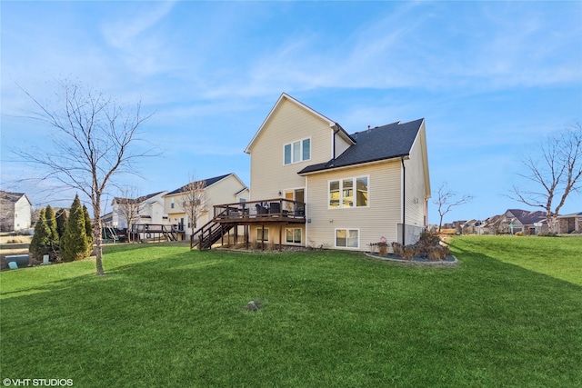 rear view of property featuring a deck and a lawn