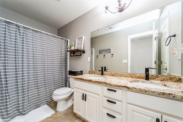 bathroom featuring tile patterned flooring, vanity, toilet, and a textured ceiling