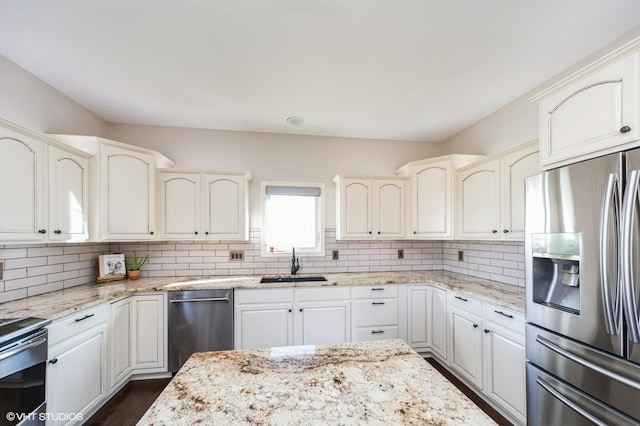 kitchen with sink, white cabinetry, tasteful backsplash, appliances with stainless steel finishes, and light stone countertops