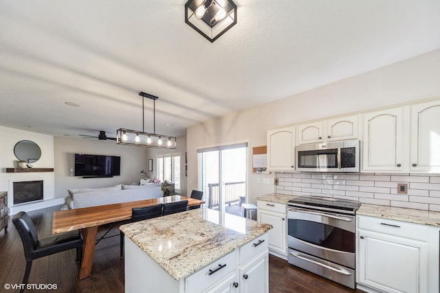 kitchen with decorative light fixtures, tasteful backsplash, dark hardwood / wood-style flooring, stainless steel appliances, and light stone countertops