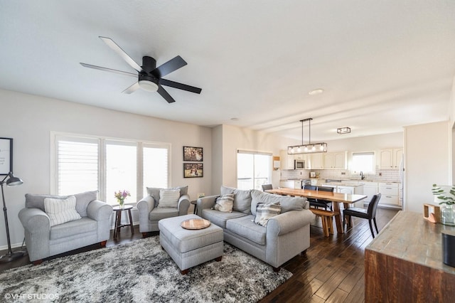 living room featuring ceiling fan and dark hardwood / wood-style floors