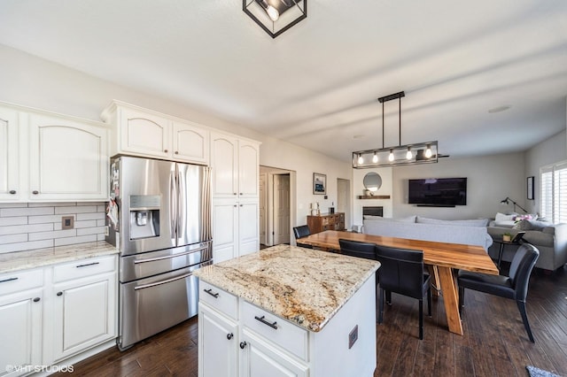 kitchen featuring pendant lighting, stainless steel fridge with ice dispenser, white cabinets, and a kitchen island