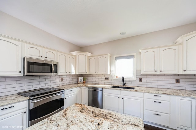 kitchen featuring stainless steel appliances, light stone countertops, sink, and backsplash