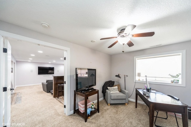 office space with ceiling fan, light carpet, and a textured ceiling