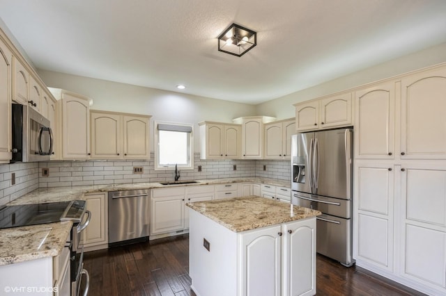 kitchen with backsplash, a sink, dark wood-style floors, and stainless steel appliances