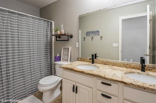 bathroom featuring toilet, tile patterned floors, double vanity, and a sink