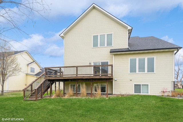 back of property featuring a yard, a wooden deck, a shingled roof, and stairs