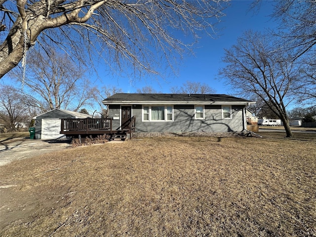 ranch-style home with a garage, an outbuilding, and a deck