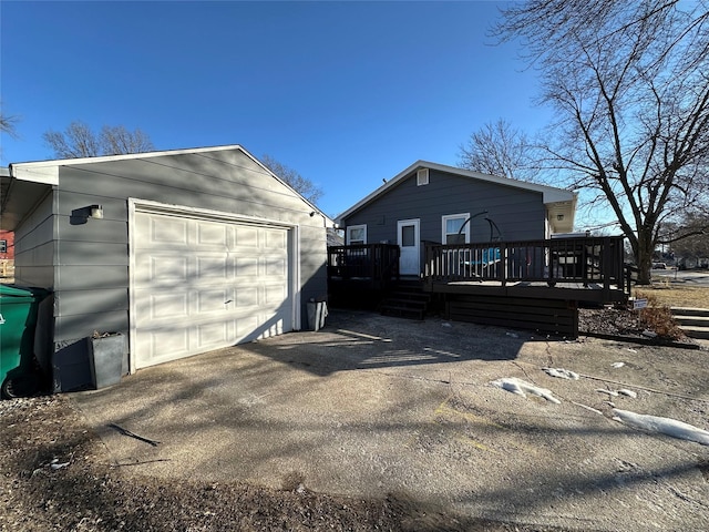 exterior space featuring a garage, an outdoor structure, and a deck