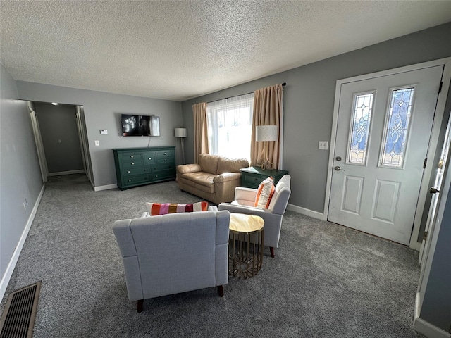 carpeted living room featuring a textured ceiling