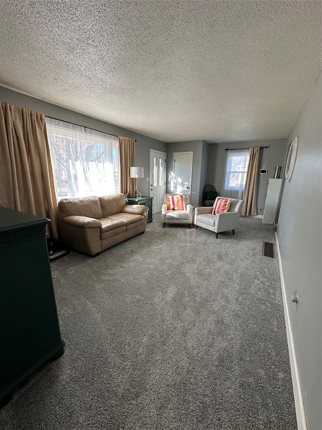 unfurnished living room featuring carpet flooring and a textured ceiling