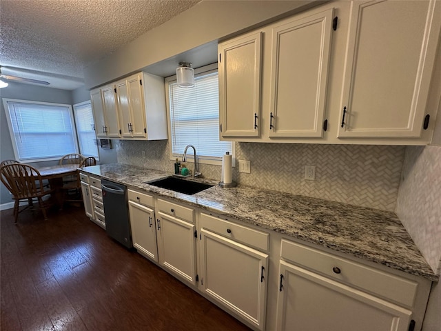 kitchen with sink, dishwashing machine, white cabinets, backsplash, and light stone counters