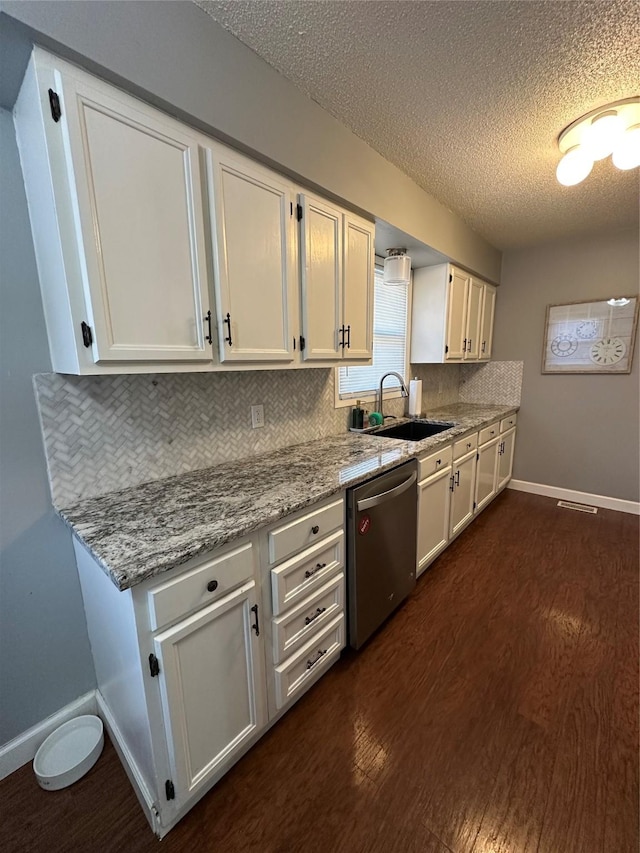 kitchen featuring white cabinetry, dishwasher, sink, light stone countertops, and a textured ceiling