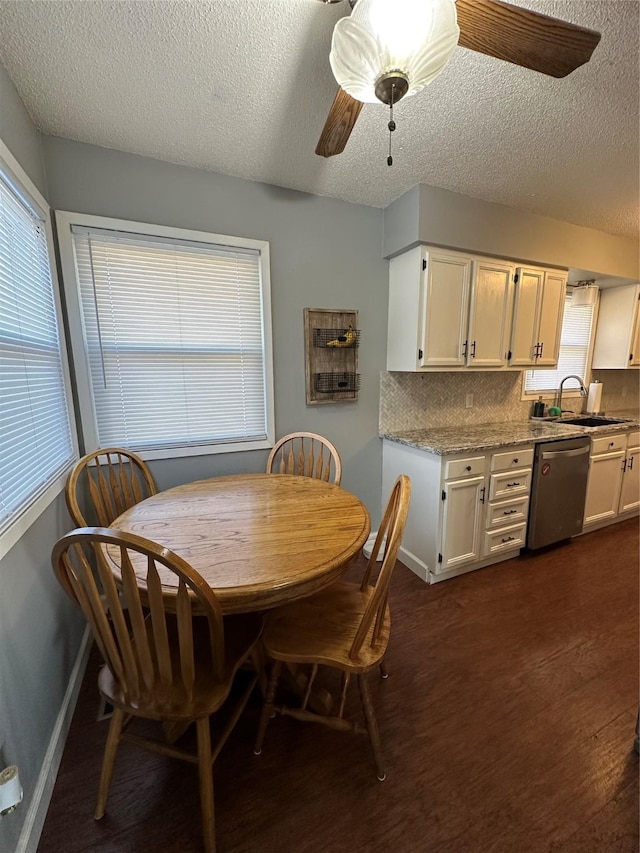 dining room featuring sink, a textured ceiling, dark hardwood / wood-style floors, a wealth of natural light, and ceiling fan