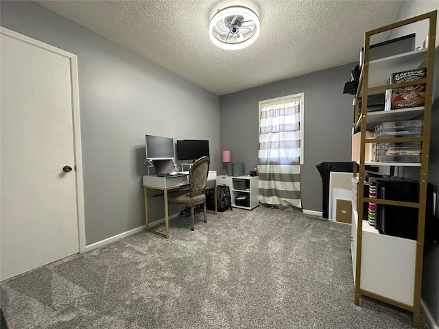 carpeted home office featuring a textured ceiling