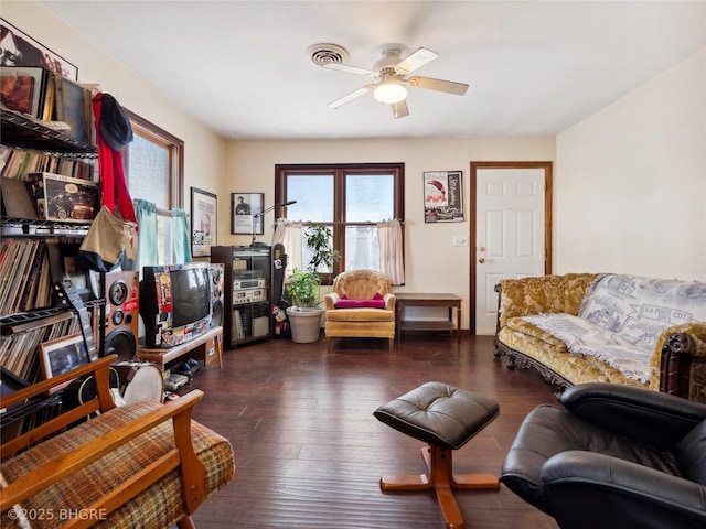 sitting room with dark wood-type flooring and ceiling fan