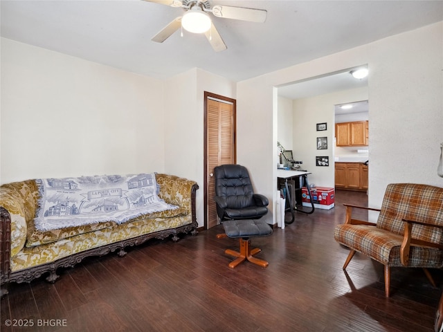 living area featuring dark hardwood / wood-style floors and ceiling fan