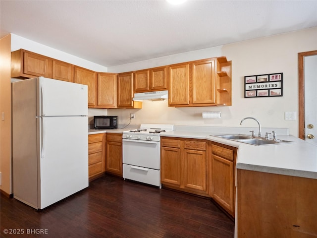 kitchen featuring white appliances, dark hardwood / wood-style floors, kitchen peninsula, and sink