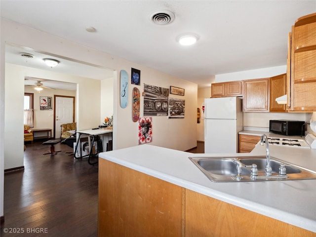 kitchen with dark wood-type flooring, sink, range, white refrigerator, and kitchen peninsula