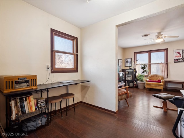 home office with ceiling fan and dark hardwood / wood-style flooring