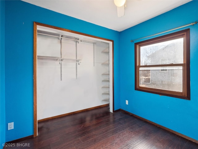 unfurnished bedroom featuring dark hardwood / wood-style flooring, a closet, and ceiling fan