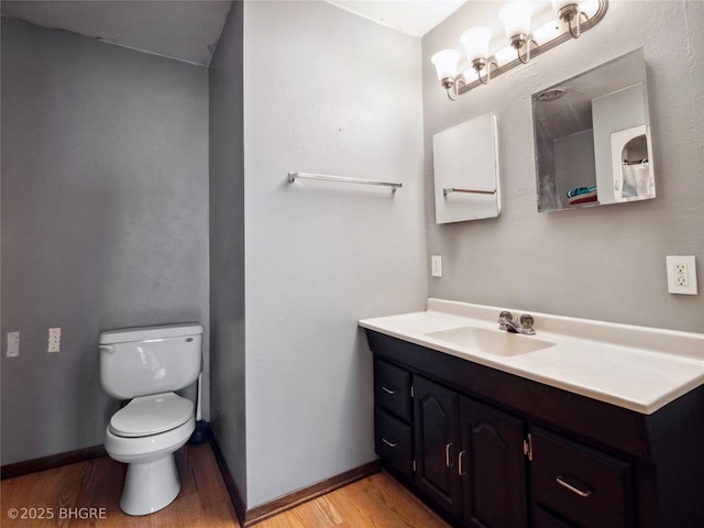 bathroom featuring wood-type flooring, vanity, and toilet