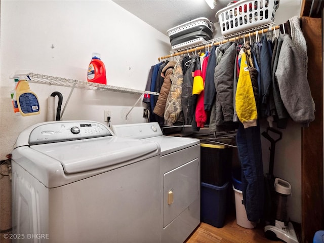 laundry area with hardwood / wood-style flooring and washing machine and dryer