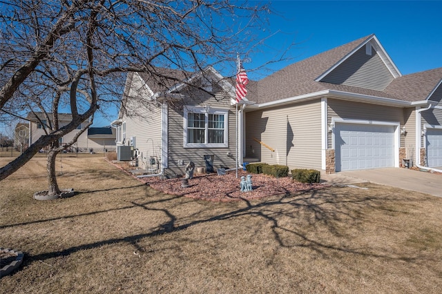 view of front facade featuring a garage, central AC unit, and a front yard