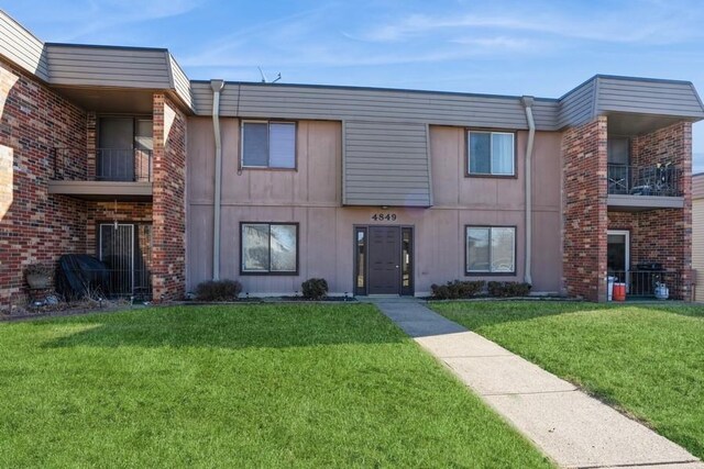 view of front of home with a front lawn and a balcony