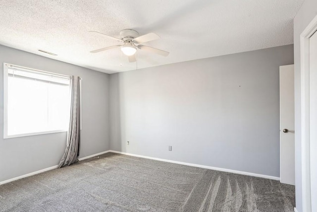 spare room with ceiling fan, carpet floors, a textured ceiling, and visible vents