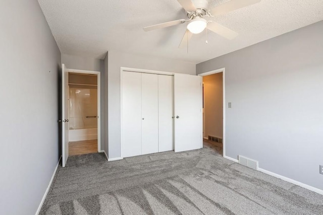 unfurnished bedroom with a closet, carpet, visible vents, and baseboards