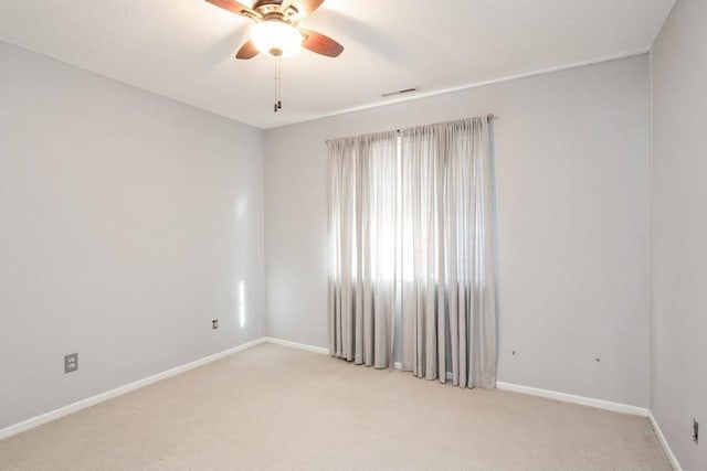 unfurnished room featuring light carpet, baseboards, visible vents, and a ceiling fan