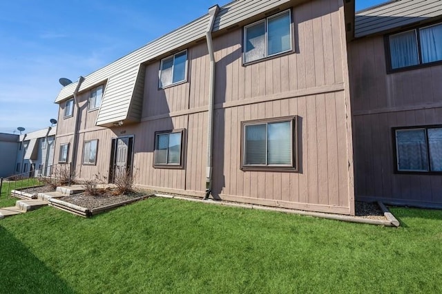 rear view of property featuring a lawn