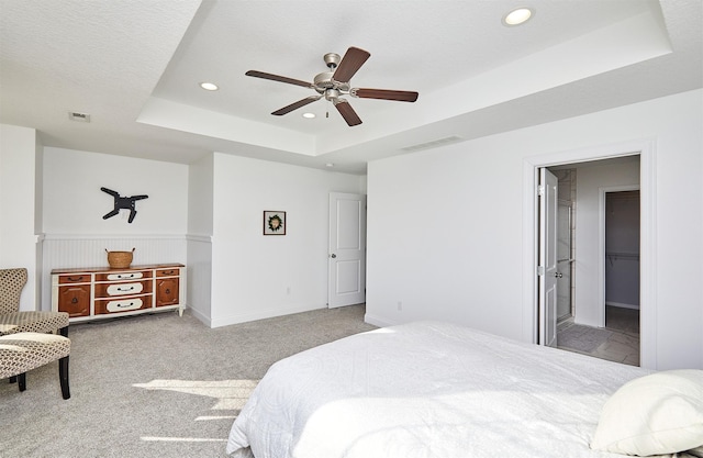 bedroom with a raised ceiling, recessed lighting, carpet, and visible vents