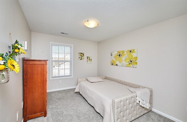 carpeted bedroom featuring visible vents, a textured ceiling, and baseboards