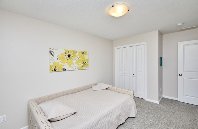 bedroom featuring visible vents, baseboards, a closet, a textured ceiling, and carpet flooring