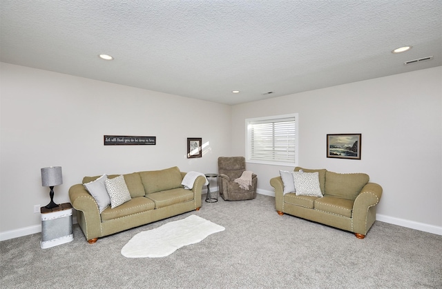 living room featuring carpet flooring, baseboards, and a textured ceiling