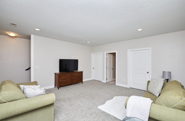 living room featuring baseboards, visible vents, recessed lighting, a textured ceiling, and light carpet