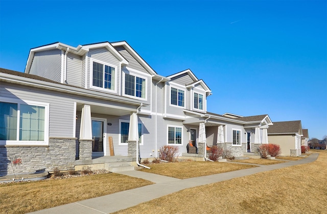 view of front of house with stone siding and a front lawn