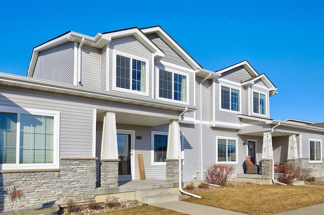 view of front of home with stone siding and covered porch