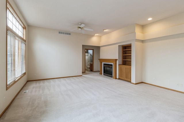 unfurnished living room featuring light carpet and ceiling fan