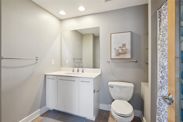 bathroom with vanity, curtained shower, and toilet