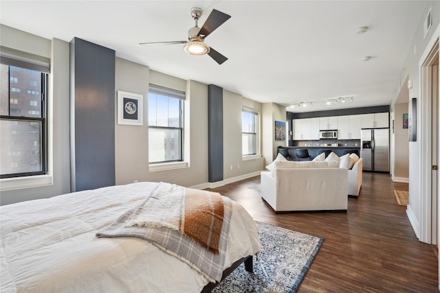 bedroom with dark hardwood / wood-style floors, ceiling fan, and stainless steel fridge