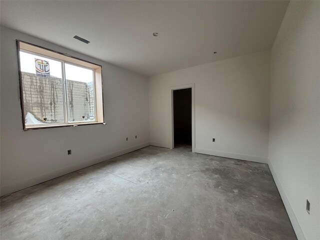 empty room with baseboards and concrete floors