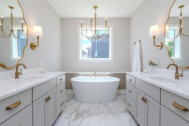 16217 Walnut Meadows Ct, Urbandale, IA 50323 - full bathroom featuring a chandelier, two vanities, a wainscoted wall, a freestanding bath, and marble look tile flooring