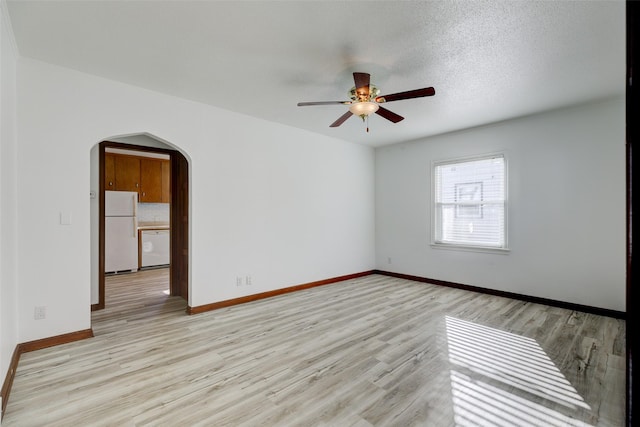 unfurnished room with a textured ceiling, light hardwood / wood-style flooring, and ceiling fan