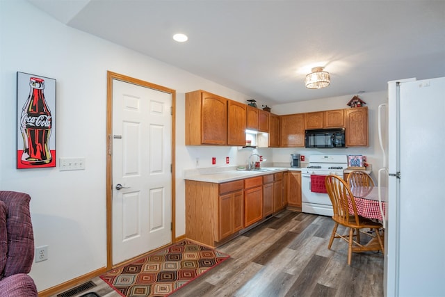 kitchen with sink, dark wood-type flooring, and white appliances